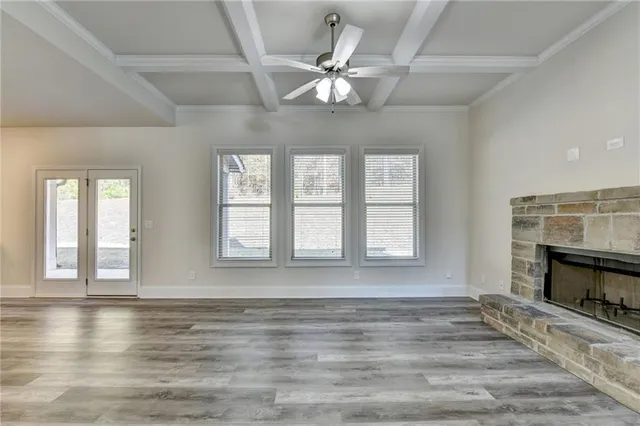 wooden floor fireplace and windows in an empty room
