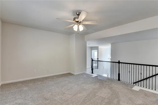 an empty room with windows and ceiling fan