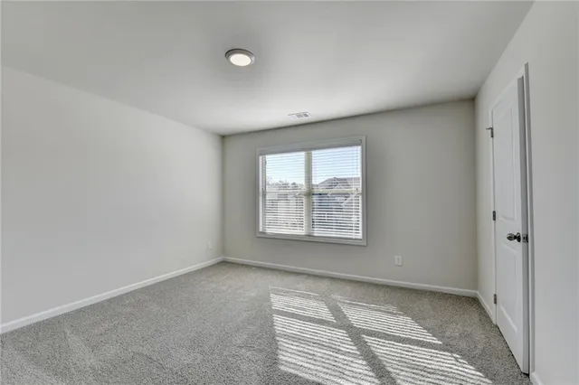 an empty room with a window and a chandelier fan