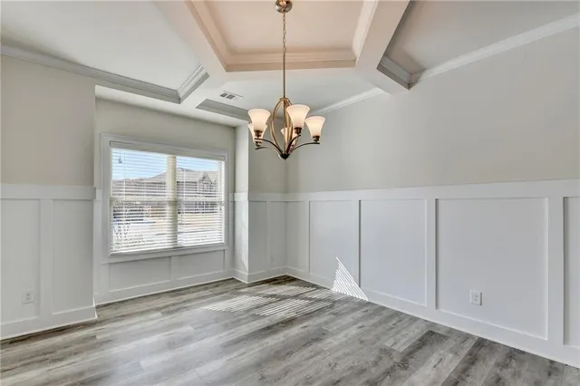 a view of a livingroom with a chandelier fan and windows