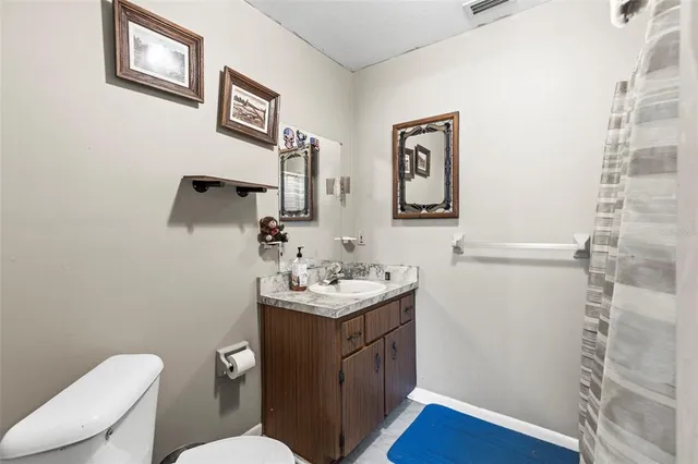 a bathroom with a sink toilet and a mirror