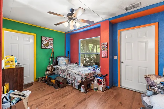 a bedroom with a bed and wooden floor