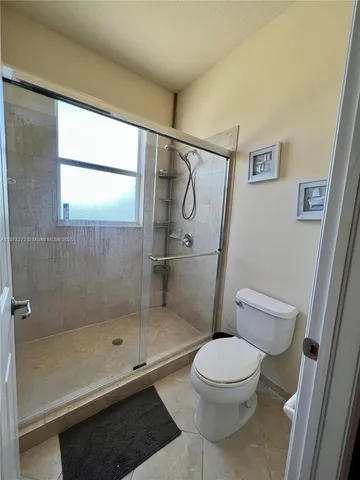 a bathroom with a toilet and a shower