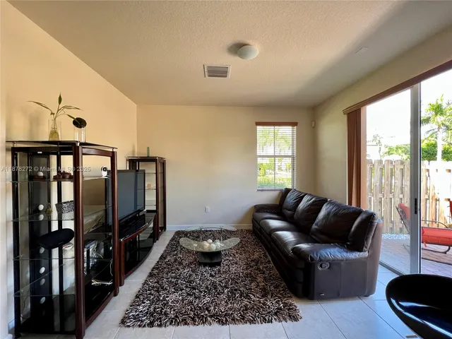 a living room with furniture tv and a window