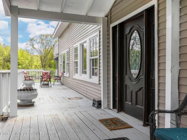 a kitchen with stainless steel appliances granite countertop a stove a sink a refrigerator and white cabinets with wooden floor