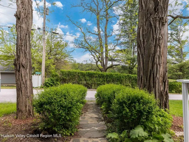 a kitchen with stainless steel appliances granite countertop a stove a sink a refrigerator a dining table and chairs with wooden floor