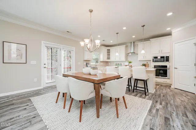 a kitchen with kitchen island a dining table and chairs