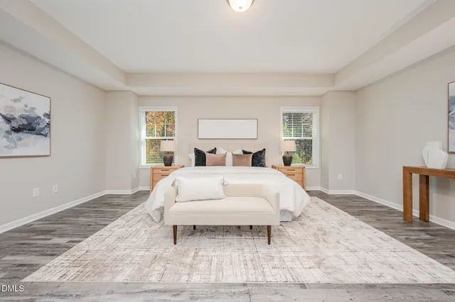 a bedroom with a large bed and wooden floor