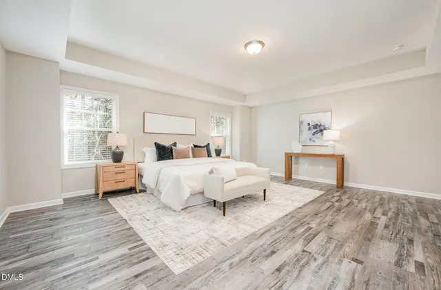 a view of a bedroom with a bed and wooden floor