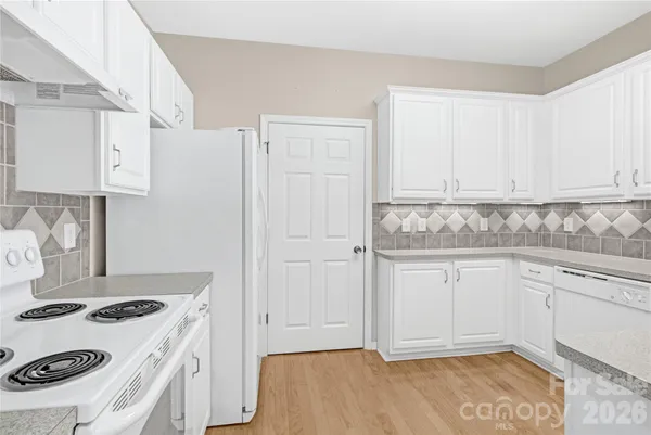 a kitchen with white cabinets and white appliances
