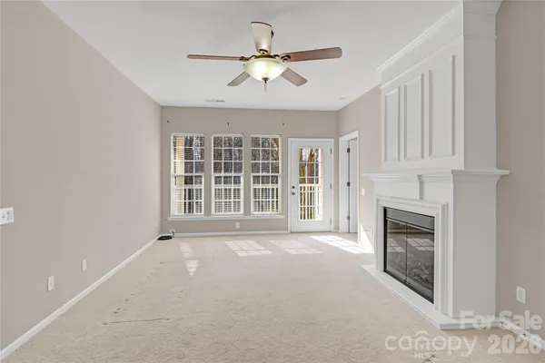 a view of an empty room with a fireplace and a window