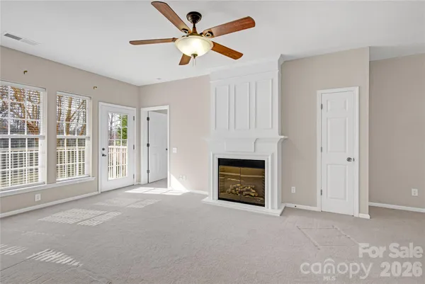 a view of an empty room with a fireplace and a window