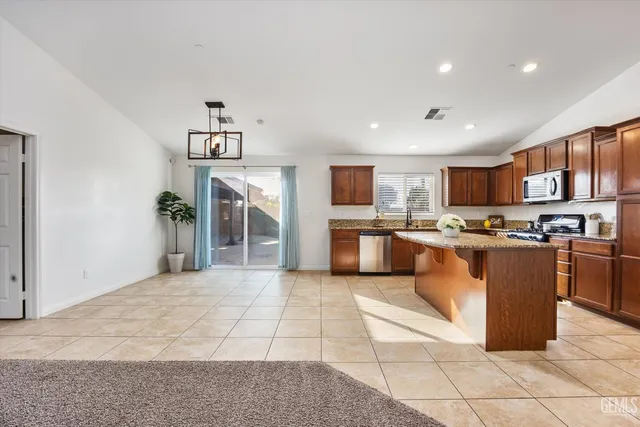 a kitchen with stainless steel appliances granite countertop a stove a sink and a microwave
