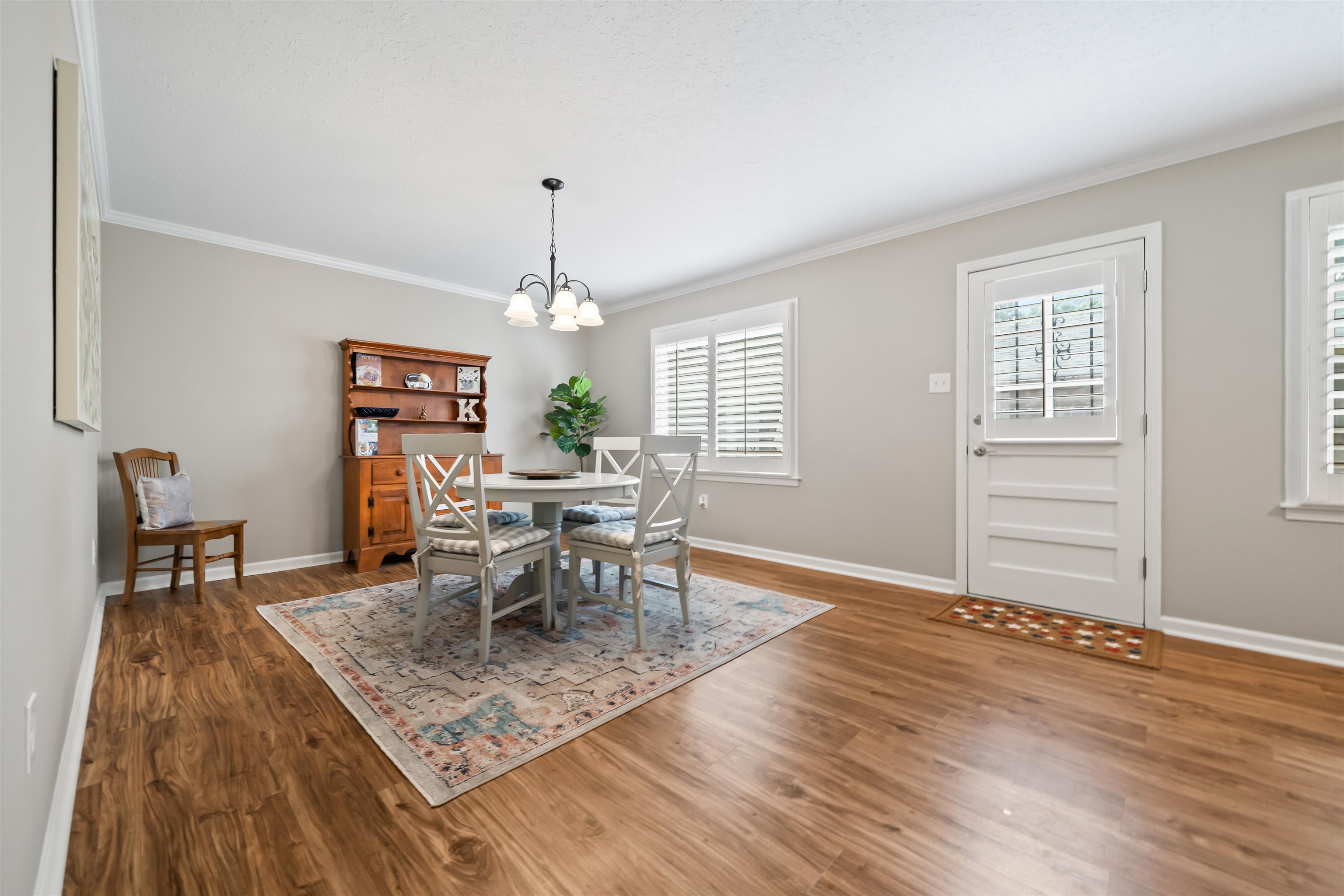 6943 Fords Station Road, Unit 64 Germantown, TN 38138 - Photo 10 of 30 Open-concept room featuring wood-finish flooring, light gray walls, white crown molding, and a chandelier-style light fixture