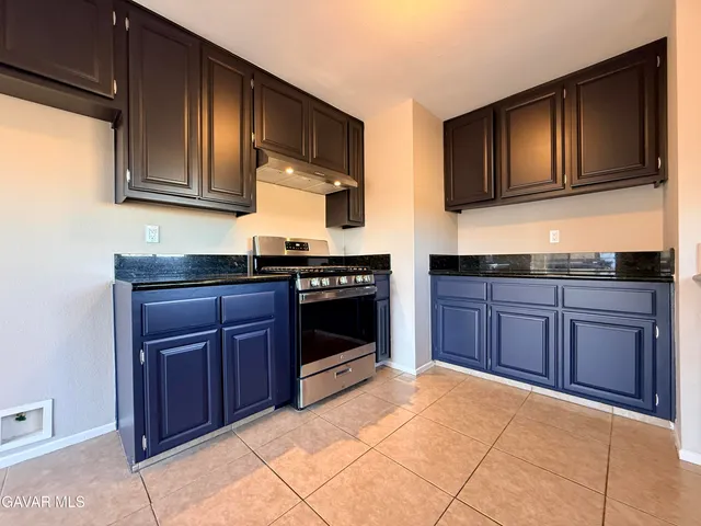 a kitchen with stainless steel appliances granite countertop wooden cabinets and a stove top oven