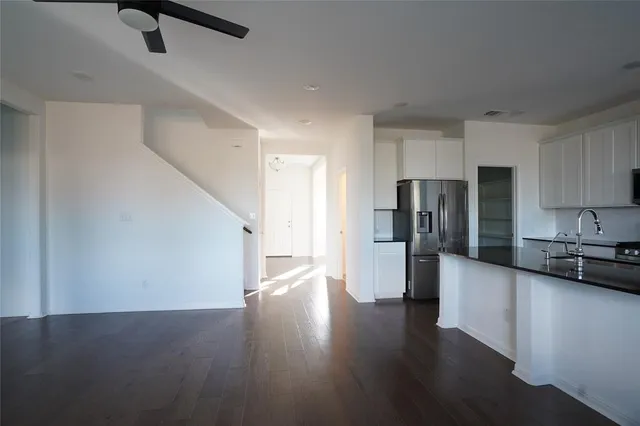 a kitchen with stainless steel appliances granite countertop a sink window and cabinets