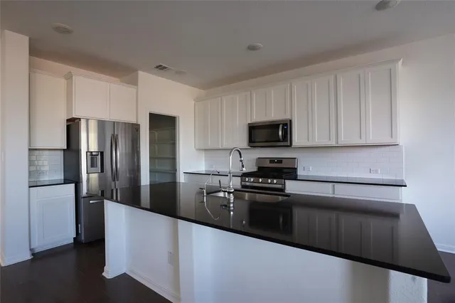 a view of a kitchen with stove a microwave and a window