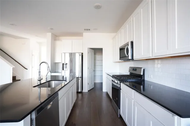 a kitchen with stainless steel appliances granite countertop a sink stove and refrigerator