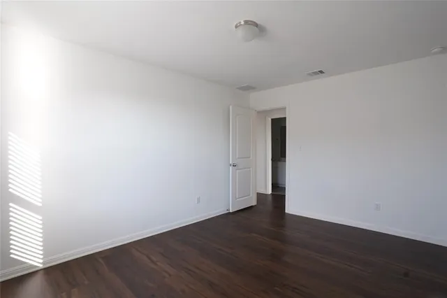 a view of a big room with wooden floor a ceiling fan and wooden floor