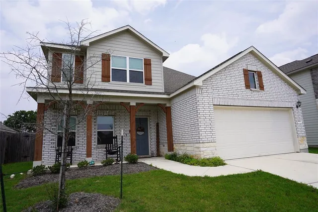 a view of a white house next to a yard and large trees