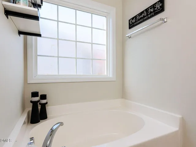 a bedroom with a bed chandelier and a window
