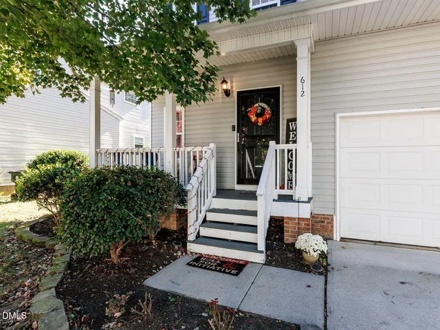 a white house that has a tree in front of it