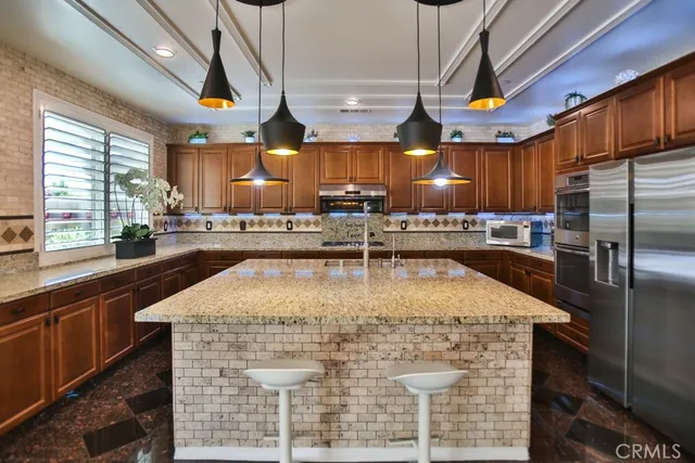 a kitchen with stainless steel appliances granite countertop a stove a sink and a microwave