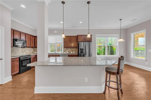 a kitchen with granite countertop a sink a counter top space appliances and cabinets