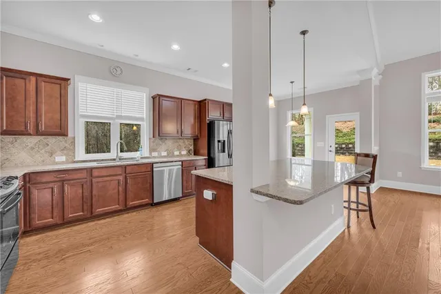 a kitchen with stainless steel appliances granite countertop a refrigerator and a stove top oven
