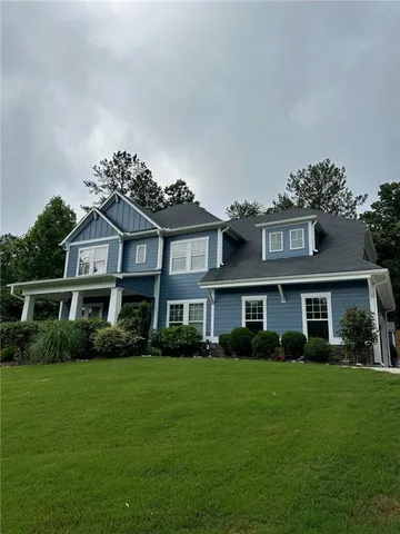 a front view of a house with yard and green space