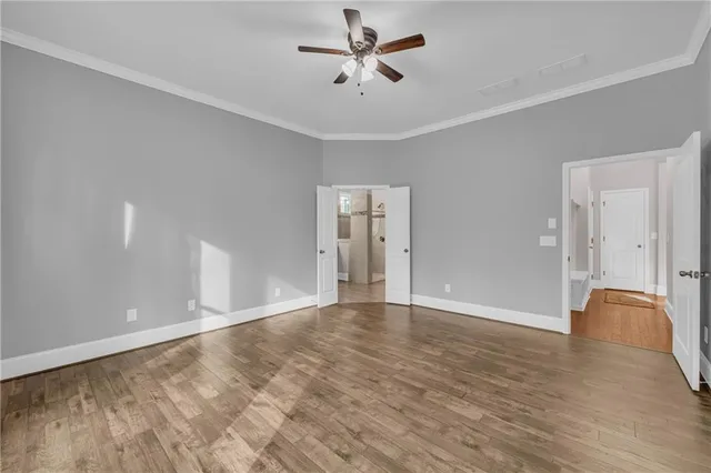 an empty room with closet and a ceiling fan