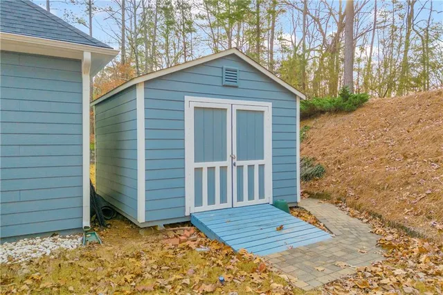 a view of a house with potted plants and a large tree