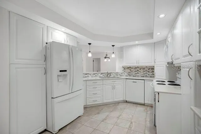 a view of an empty room with chandelier fan and a window