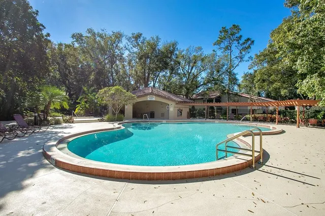a view of a tennis ground with large trees