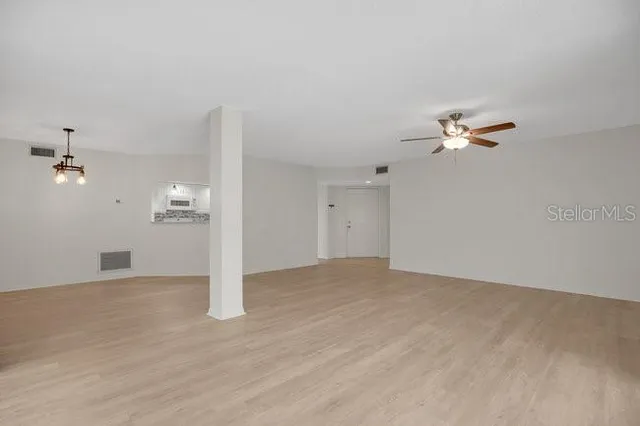 a view of an empty room with a kitchen