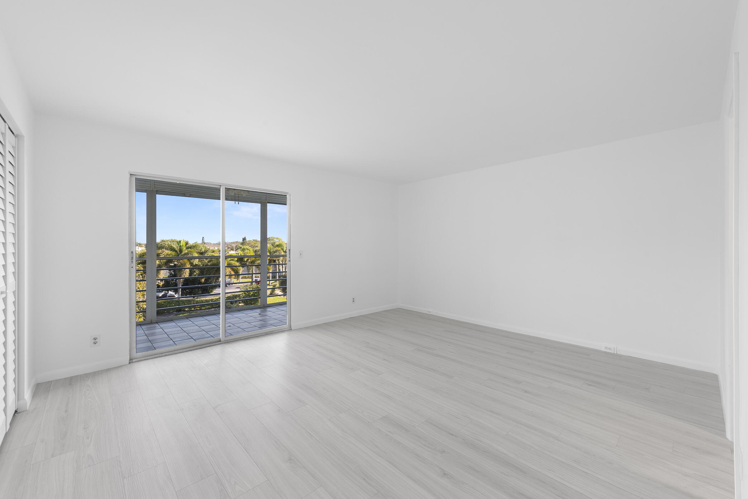 4043 Rexford Drive, Unit 4043 Boca Raton, FL 33434 - Photo 10 of 27 an empty room with wooden floor and windows