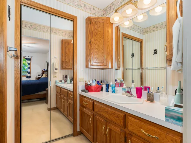 a bathroom with a tub sink vanity and mirror