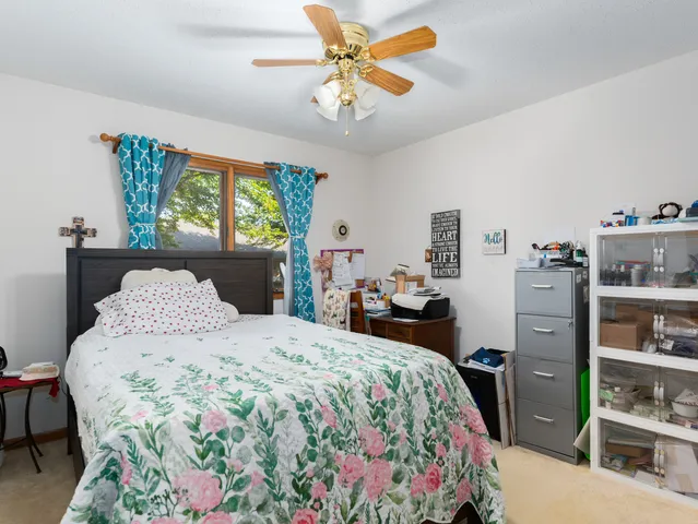 a bedroom with a bed a dresser and a book shelf