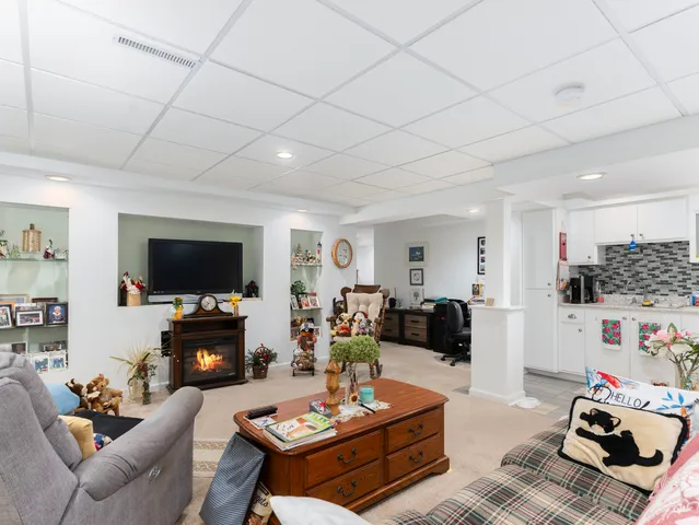 a living room with furniture a flat screen tv and a fireplace