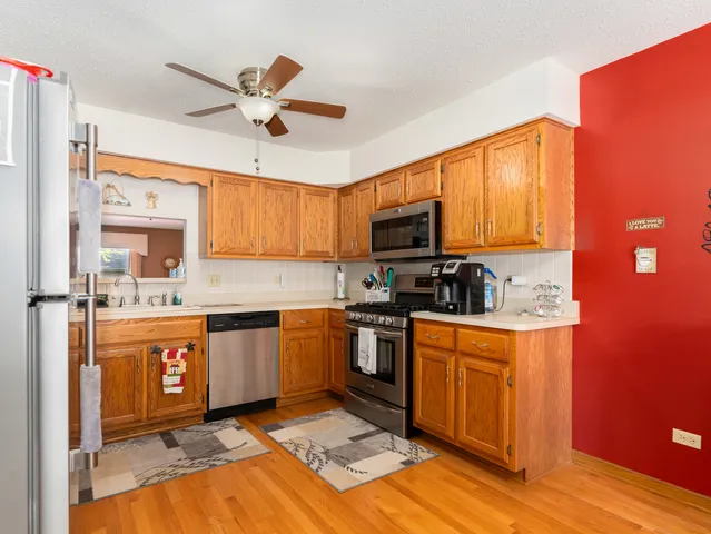 a kitchen with stainless steel appliances granite countertop a sink dishwasher stove top oven and cabinets