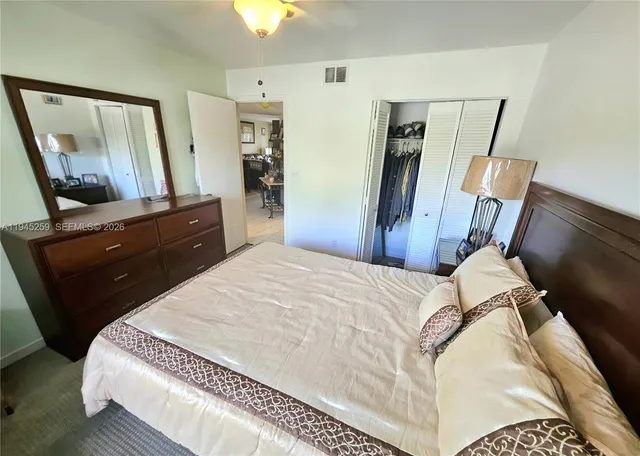 a bedroom with a bed and a mirror on dresser
