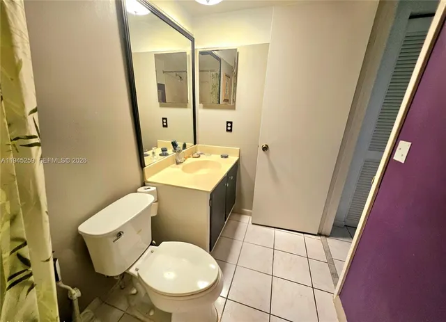 a white toilet sitting next to a bathroom sink and a mirror