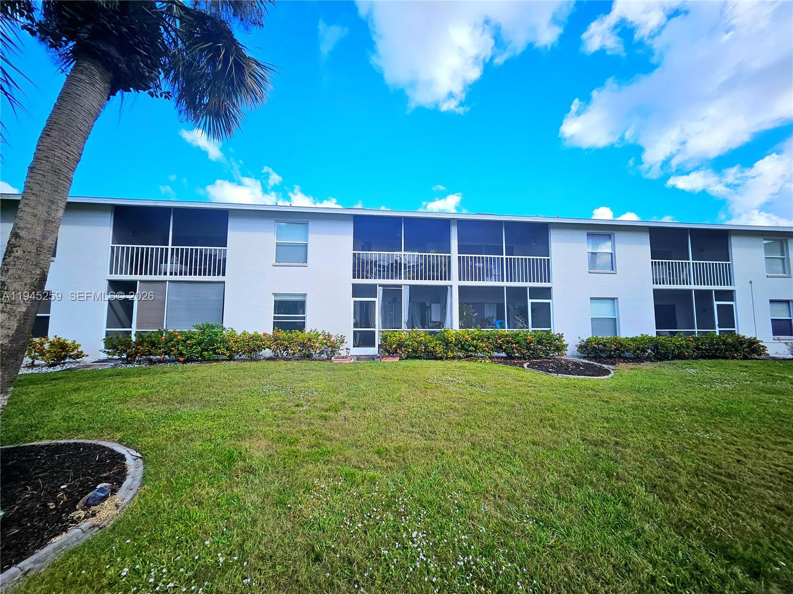 1448 Churchill Circle, Unit 103 Naples, FL 34116 - Photo 28 of 37 a front view of a house with a yard
