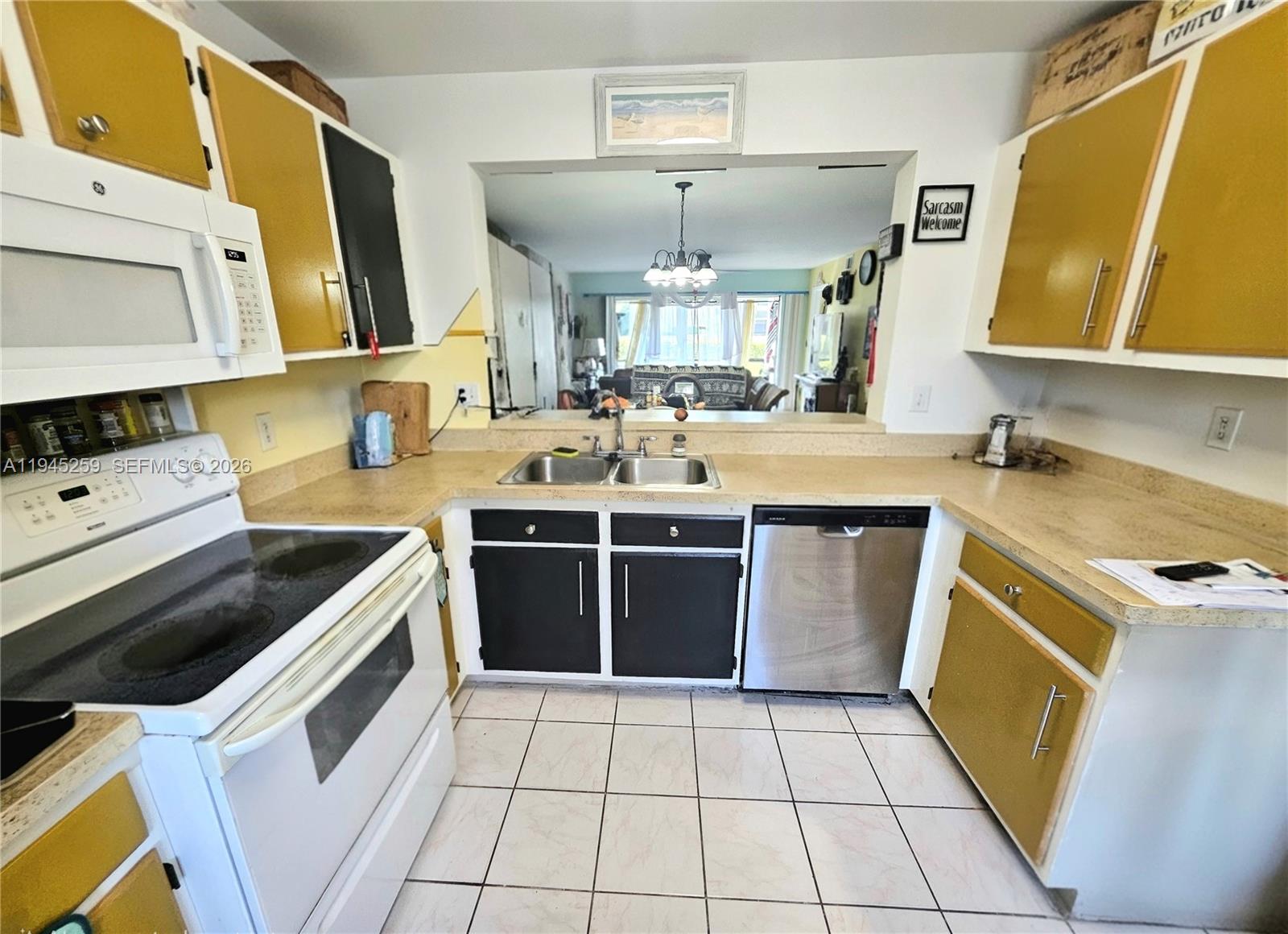 1448 Churchill Circle, Unit 103 Naples, FL 34116 - Photo 5 of 37 a kitchen with a stove sink and a microwave