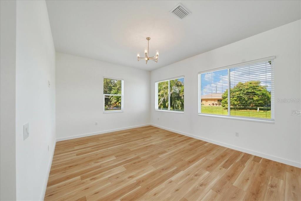 1215 Rio De Janeiro Avenue Punta Gorda, FL 33983 - Photo 18 of 65 wooden floor in an empty room with a window
