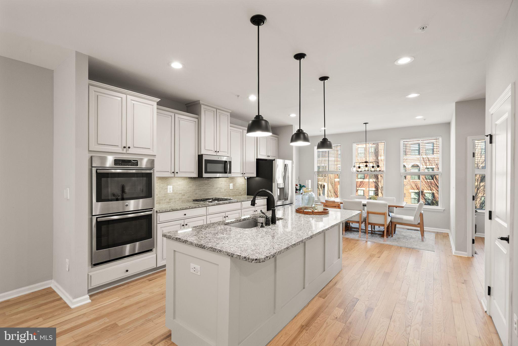 43405 Charitable Street Ashburn, VA 20148 - Photo 12 of 44 a kitchen with kitchen island granite countertop a sink counter and stainless steel appliances