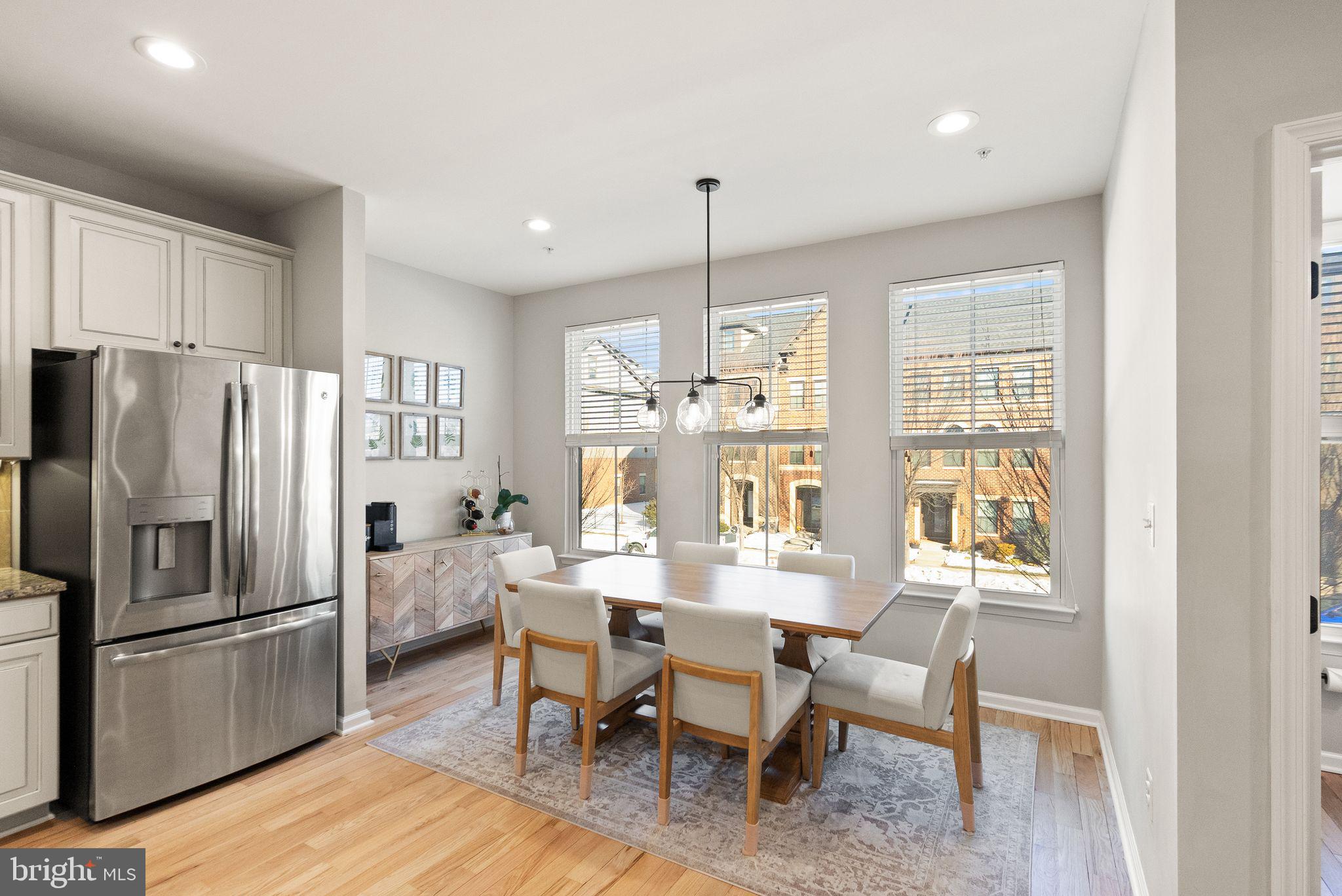 43405 Charitable Street Ashburn, VA 20148 - Photo 13 of 44 a kitchen with refrigerator cabinets dining table and chairs