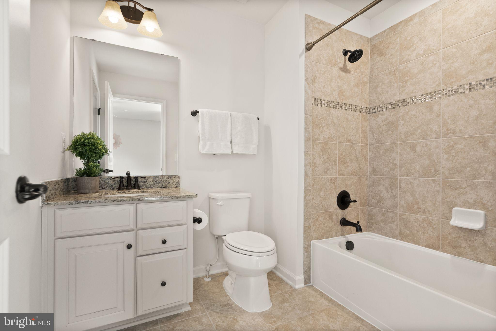 43405 Charitable Street Ashburn, VA 20148 - Photo 33 of 44 a bathroom with a granite countertop sink a toilet and a bathtub