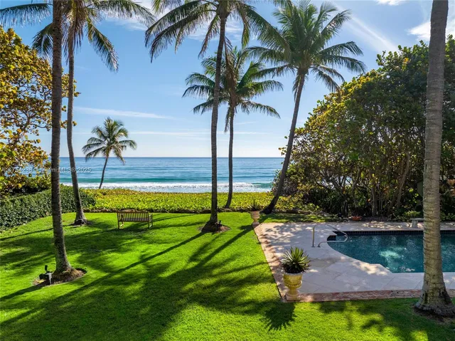 an aerial view of residential houses with outdoor space and trees