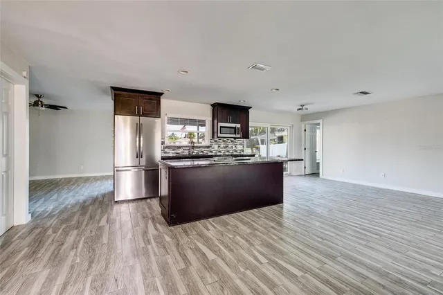 a large kitchen with stainless steel appliances granite countertop a large counter top and a stove top oven